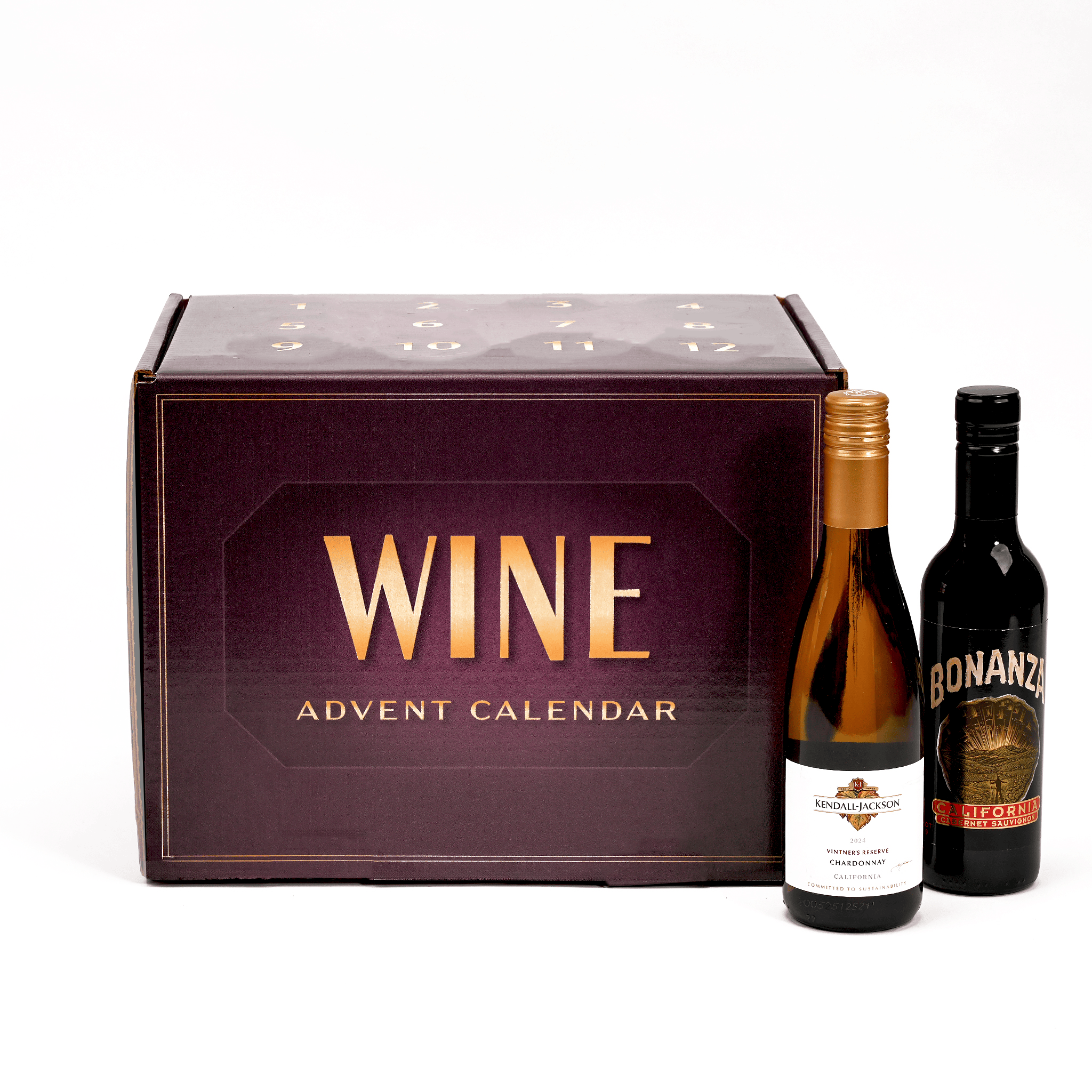 A wine advent calendar featuring a large dark plum box with gold lettering that reads 'WINE ADVENT CALENDAR', alongside two half bottles